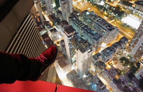 File - Urban explorer "Jonathan Tsang" dangling a foot over the side of a building in Hong Kong, December 2, 2013. (AFP PHOTO / JEROME TAYLOR)