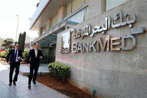 People walk past the BankMed headquarters in Beirut, Monday, March 31, 2014. (The Daily Star/Mohammad Azakir)