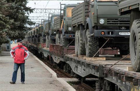 A man looks at Russian army trucks on freight carriages at the settlement of Gvardeiskoye near the Crimean city of Simferopol April 1, 2014. (REUTERS/Stringer)