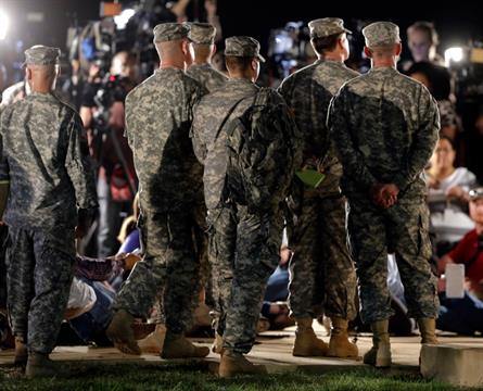 Soldiers listen in the wings as Lt. Gen. Mark Milley address the media during a news conference at the main gate to Fort Hood, Wednesday, April 2, 2014, in Fort Hood, Texas. (AP Photo/Eric Gay)