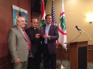 Lebanese Forces USA Coordinator Maurice Daaboul and Detroit Chapter President Tony Malouf present Bishop A. Elias Zaidan with an honorary plaque.