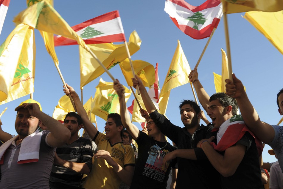 Supporters of Lebanon's Hezbollah wave Lebanese and Hezbollah flags as they listen to a televised address by Hassan Nasrallah during a rally in Nabi Sheet. (Reuters)